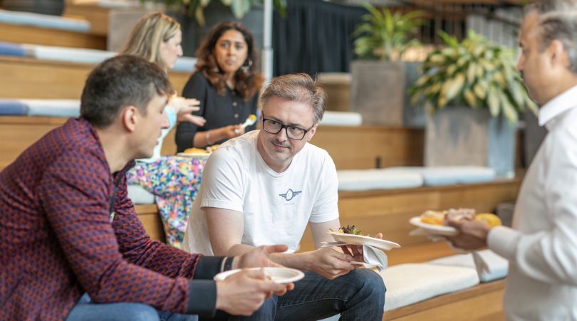 Advisor360° employees chat on a riser.